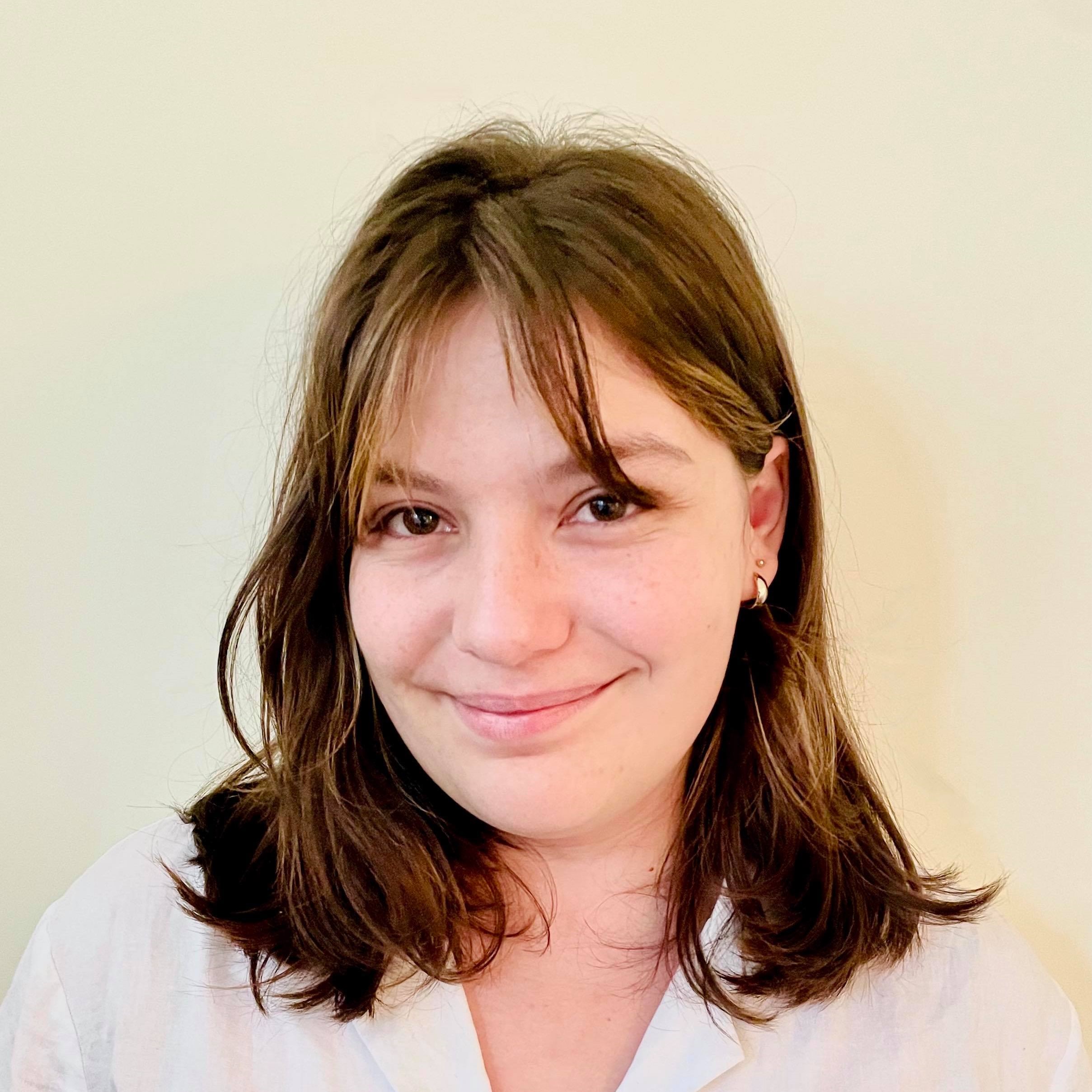 A photo of a women with brown hair and brown eyes from the shoulders up.